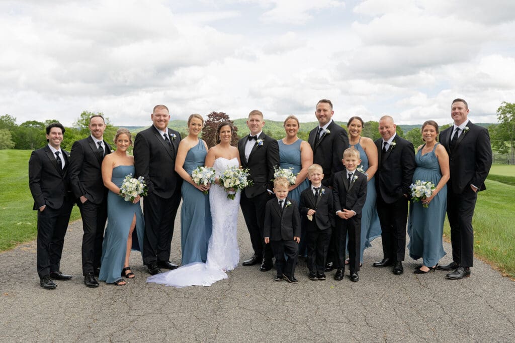 large bridal party wearing black and blue posing for a portrait