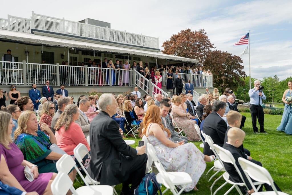 guests waiting for the ceremony to start at an outdoor wedding with a porch