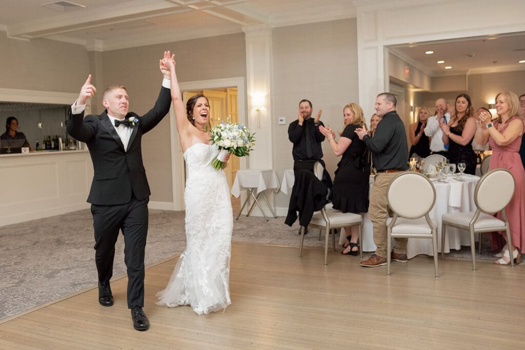 bride and groom cheering as they walk into the room