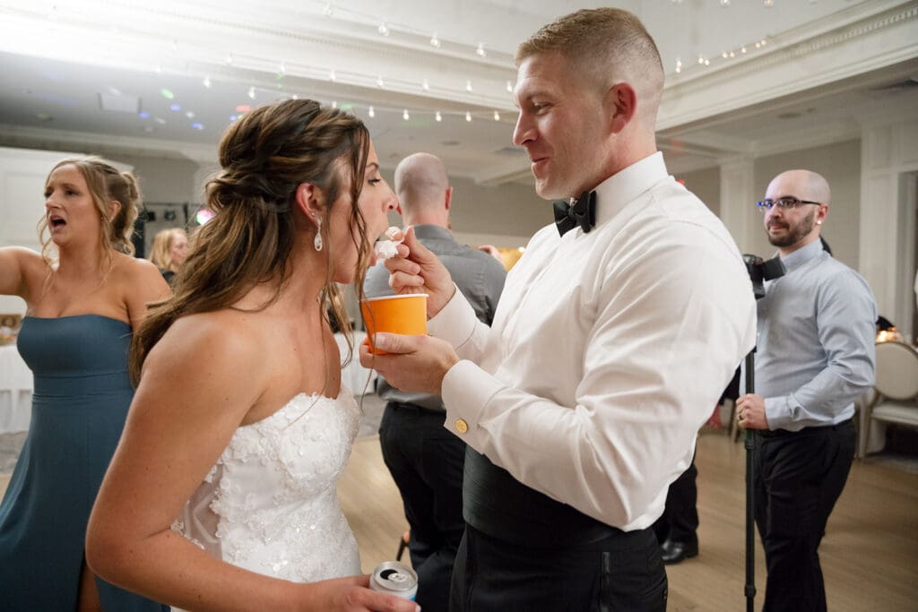 groom feeding bride ice cream while on the dance floor