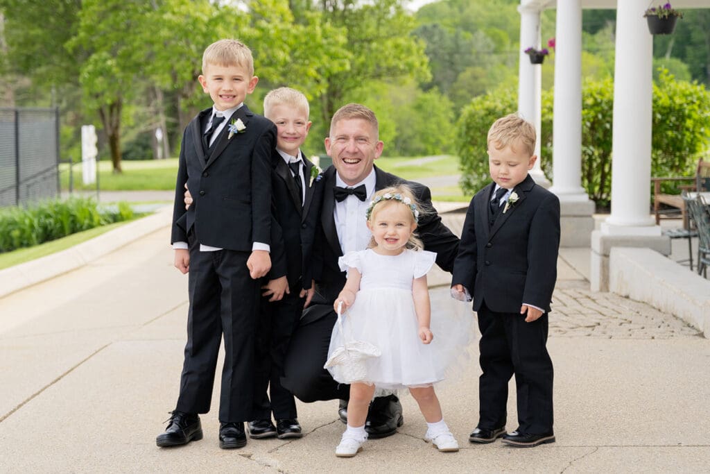 groom posing with four happy children
