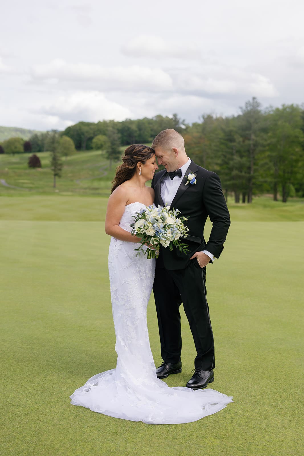 bride and groom resting their heads together during outdoor portraits