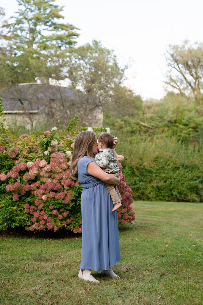 a mom in a soft blue dress consoling her baby