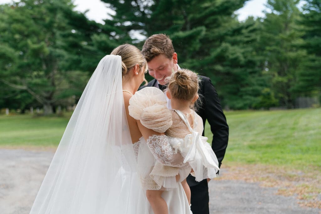 bride and toddler in a fluffy cute dress talking to groom