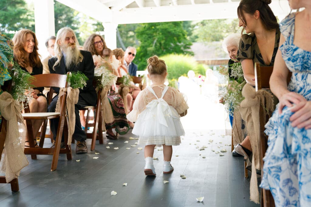flower girl walks back down aisle in fluffy white dress