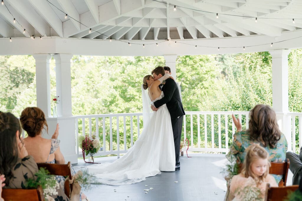 couple shares their first kiss on porch in front of family